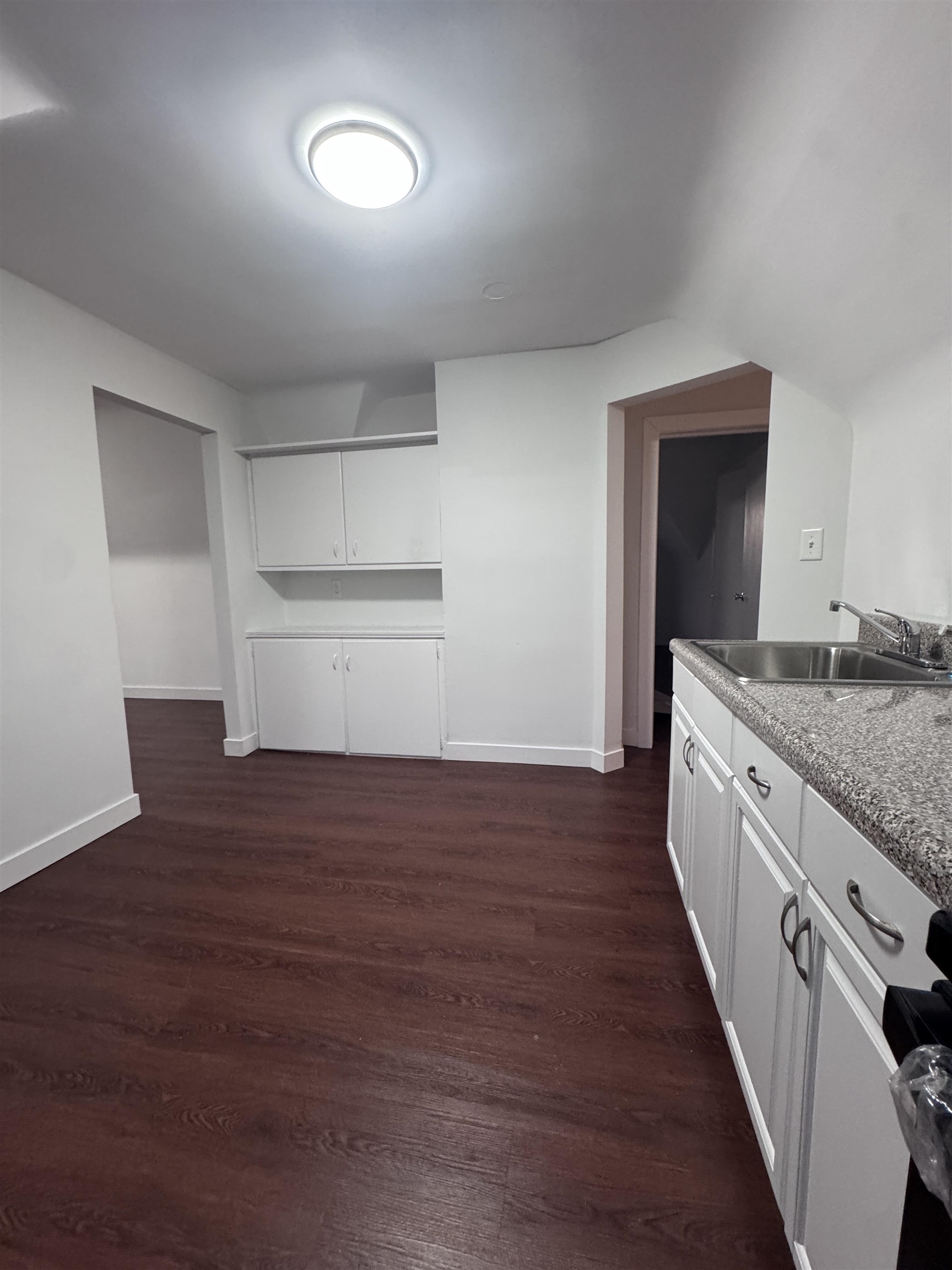 510 Shaler Boulevard, Unit 3 Ridgefield, NJ 07657 - Photo 3 of 7 a kitchen with granite countertop white cabinets and wooden floor