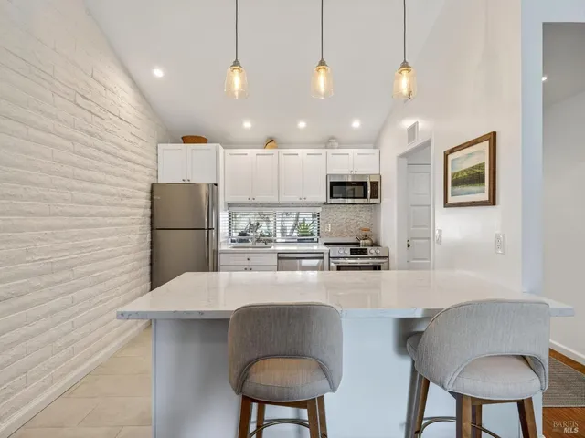 a kitchen with refrigerator and chairs