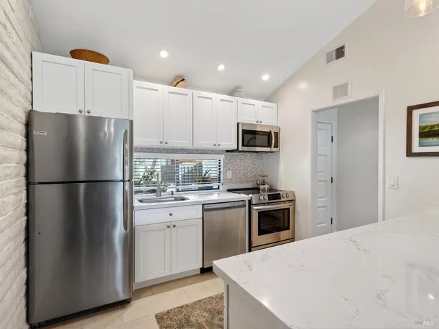 a kitchen with a refrigerator a stove top oven a sink and cabinets
