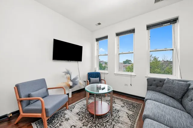 a living room with furniture a flat screen tv and a window