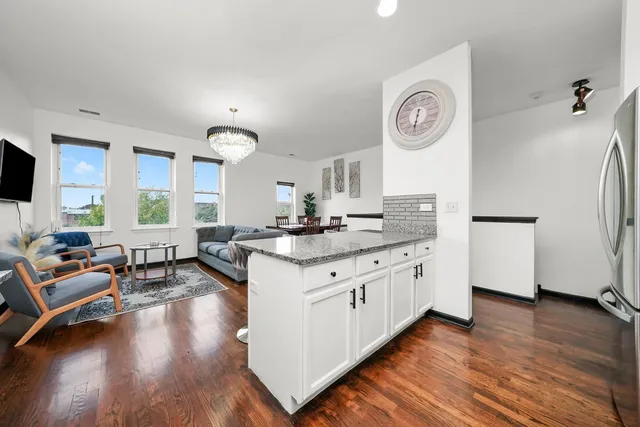 a large kitchen with kitchen island granite countertop wooden floors and a sink