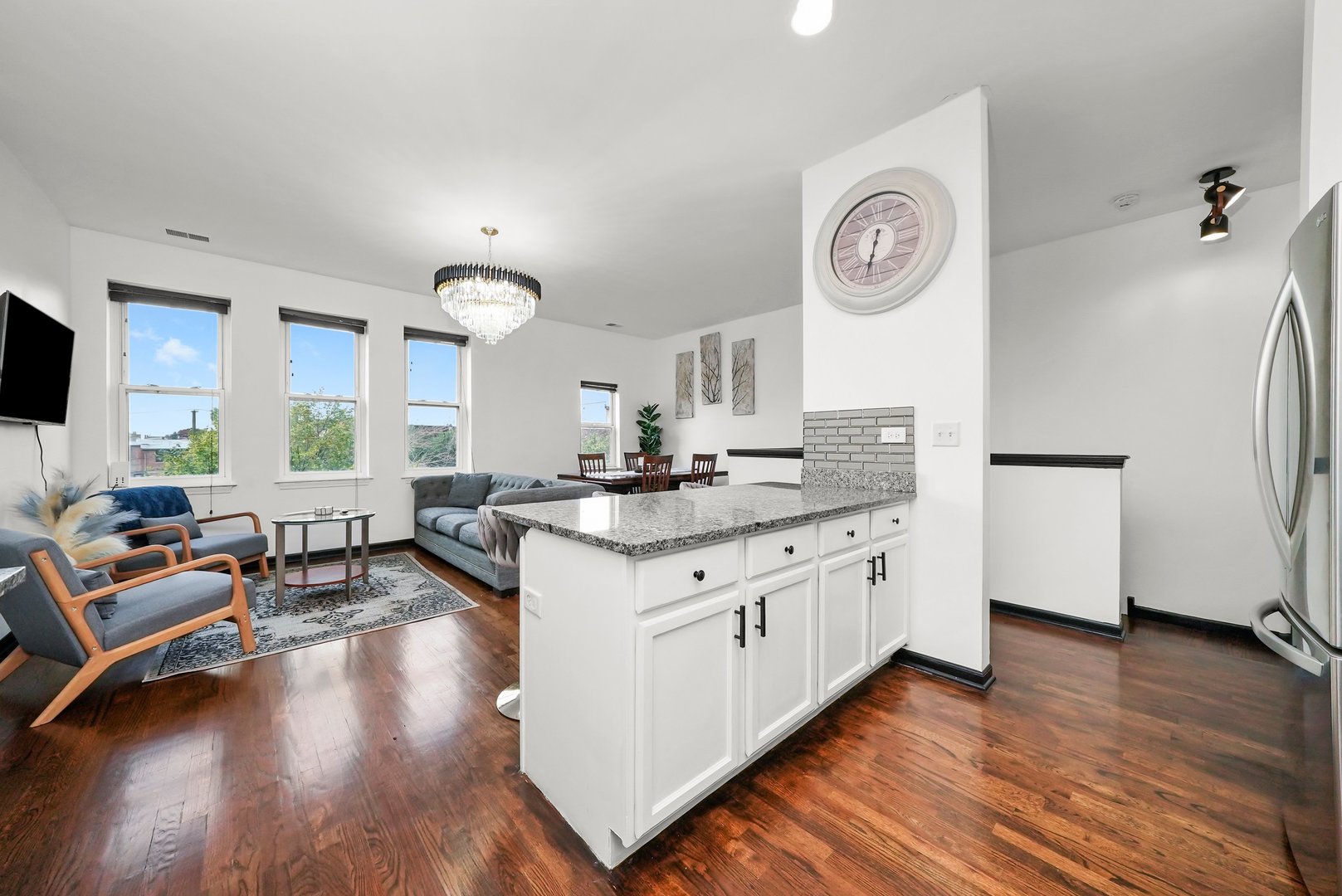 2432 West Harrison Street, Unit 3 Chicago, IL 60612 - Photo 16 of 32 a large kitchen with kitchen island granite countertop wooden floors and a sink