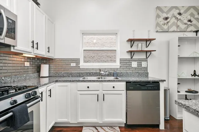 a kitchen with granite countertop white cabinets and white appliances
