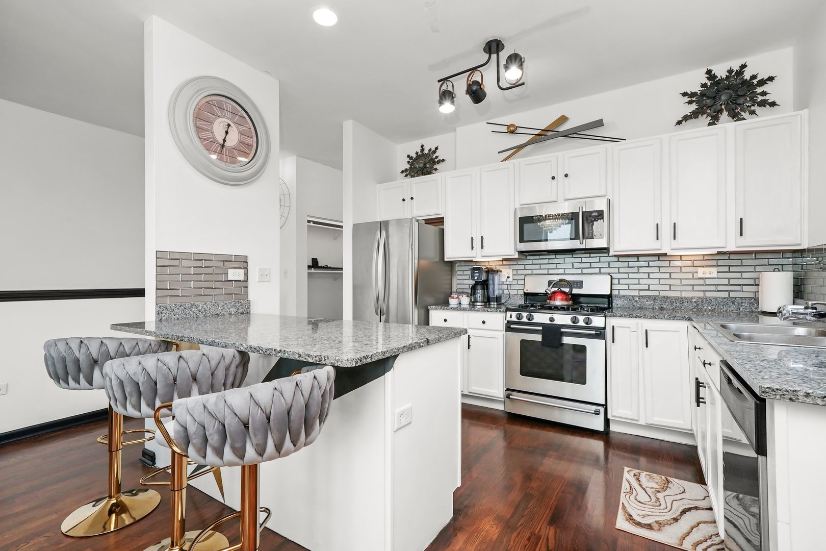 2432 West Harrison Street, Unit 3 Chicago, IL 60612 - Photo 20 of 32 a kitchen with granite countertop a stove a sink dishwasher a dining table and chairs with wooden floor