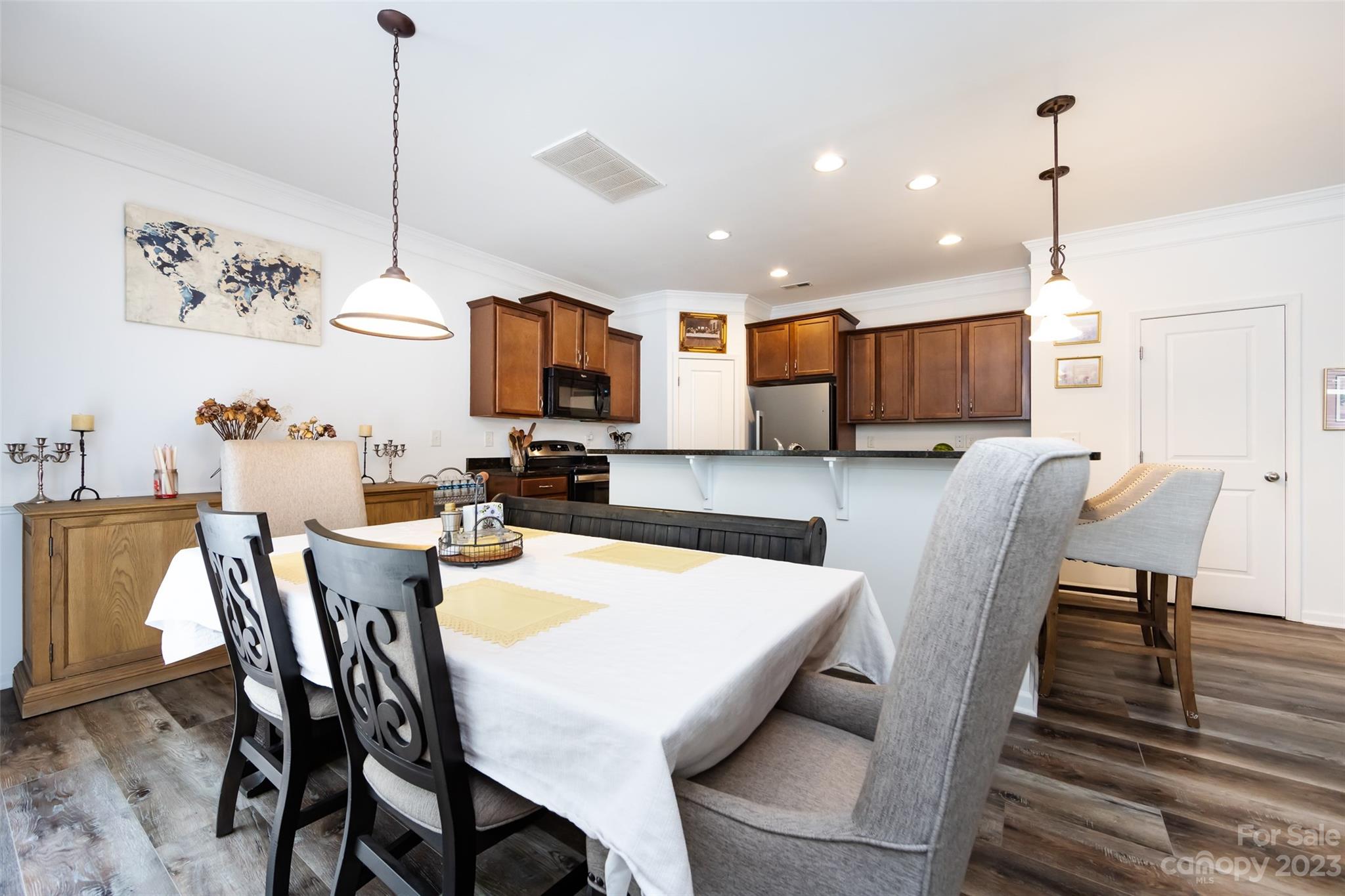 807 Rook Road Charlotte, NC 28216 - Photo 14 of 43 a view of kitchen with granite countertop a stove a sink a dining table and chairs with wooden floor