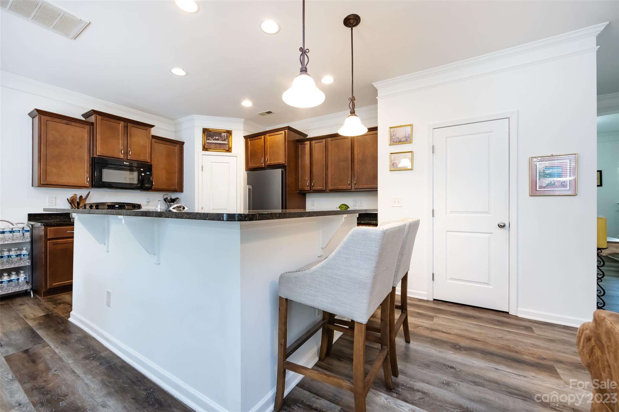 807 Rook Road Charlotte, NC 28216 - Photo 16 of 43 a kitchen with a table chairs refrigerator and microwave
