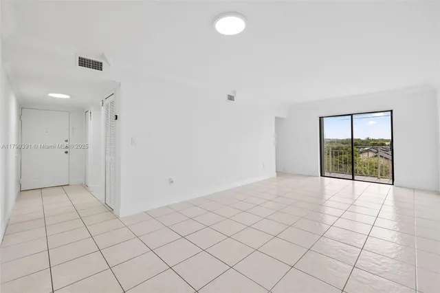 an empty room with sliding door and shower