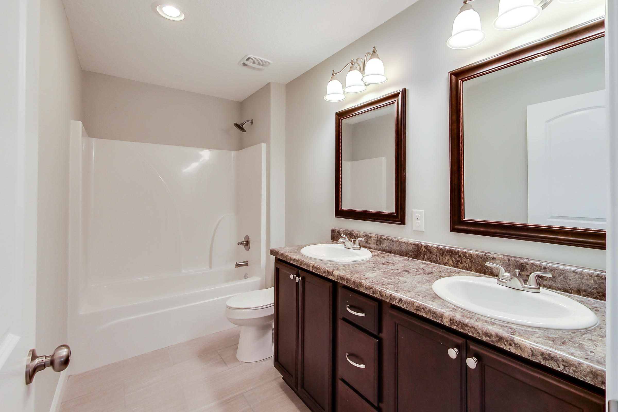196 Johnson Court Crestview, FL 32536 - Photo 19 of 23 a bathroom with a granite countertop sink double mirror bathtub shower and a toilet