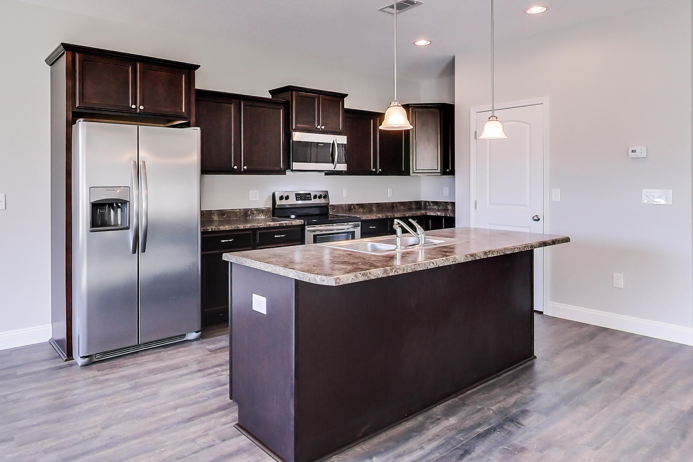 196 Johnson Court Crestview, FL 32536 - Photo 4 of 23 a kitchen with stainless steel appliances granite countertop a sink a refrigerator and a microwave