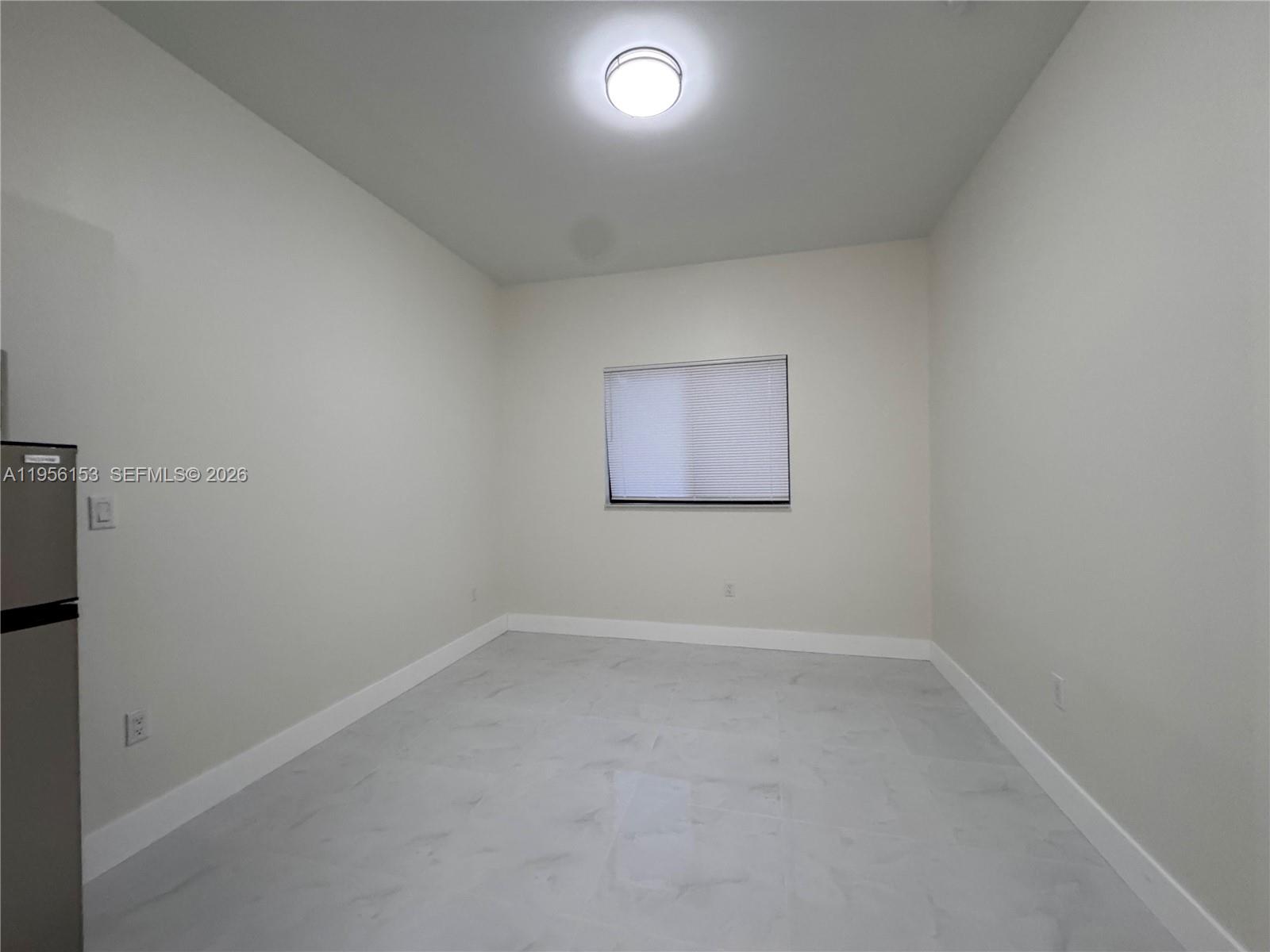 915 Northwest 104th Street, Unit BBACK Miami, FL 33150 - Photo 2 of 7 an empty room with a empty space and windows