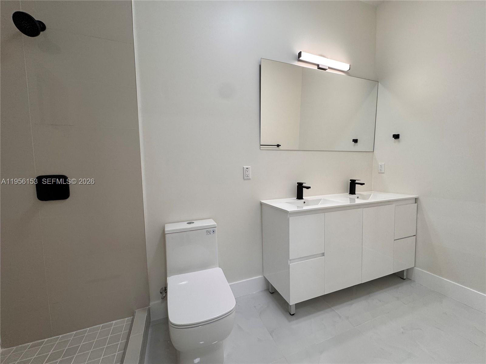 915 Northwest 104th Street, Unit BBACK Miami, FL 33150 - Photo 6 of 7 a bathroom with a sink a toilet and mirror