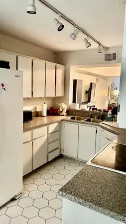 a kitchen with white cabinets and white appliances