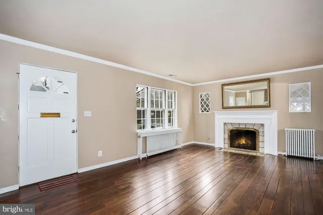 wooden floor fireplace and windows in an empty room