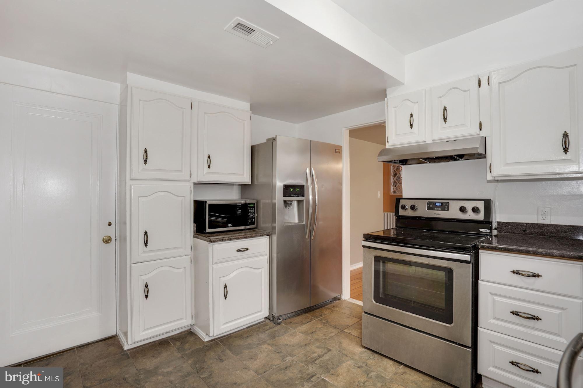 3209 19th Road North Arlington, VA 22201 - Photo 9 of 35 a kitchen with white cabinets and stainless steel appliances