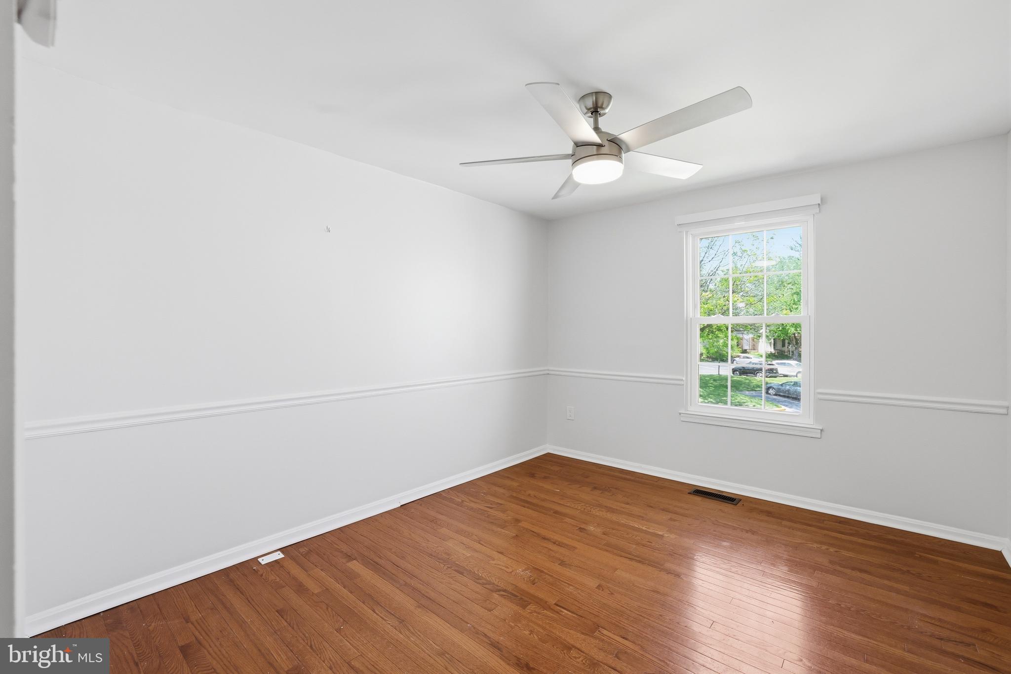 15029 Shamrock Ridge Road Silver Spring, MD 20906 - Photo 29 of 44 an empty room with wooden floor fan and windows