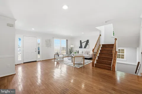 a view of empty room with wooden floor and stairs
