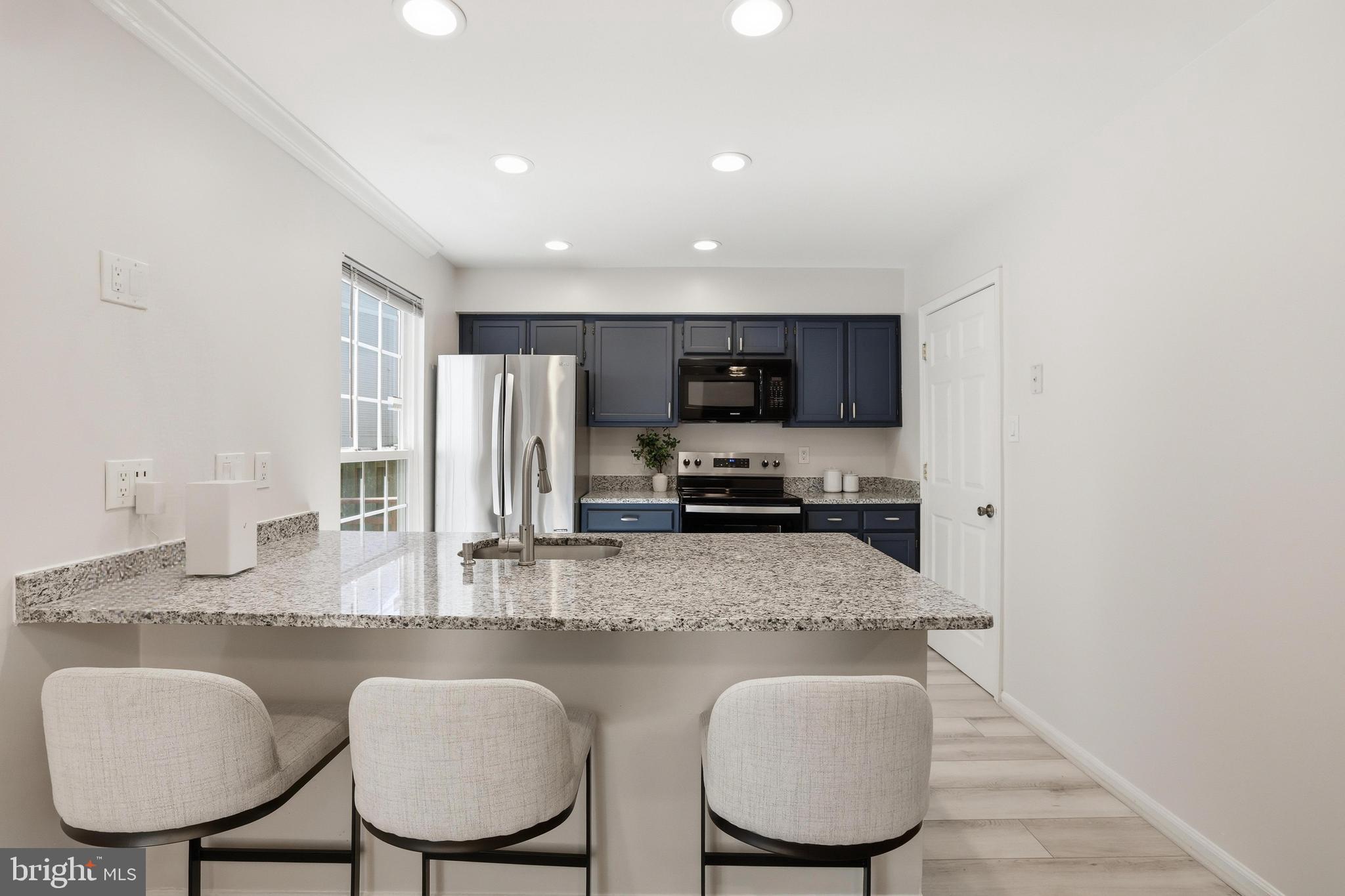 15029 Shamrock Ridge Road Silver Spring, MD 20906 - Photo 10 of 44 a kitchen with stainless steel appliances granite countertop a table chairs microwave and sink