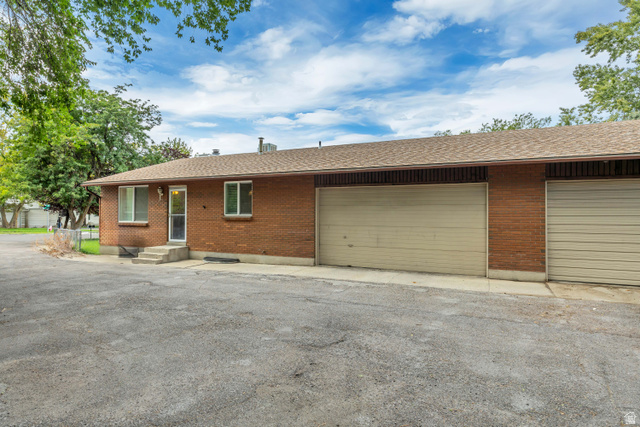 6709 Acoma Road, Unit 239 Midvale, UT 84047 - Photo 1 of 38 Unit 6711 Brick exterior with multiple garage doors and an asphalt driveway