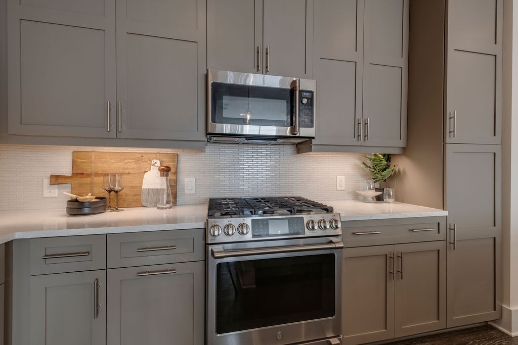 20 Rutledge Street, Unit 111 Nashville, TN 37210 - Photo 4 of 32 a kitchen with stainless steel appliances granite countertop white cabinets a stove a sink and dishwasher