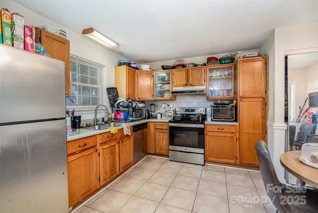 a kitchen with stainless steel appliances granite countertop a refrigerator sink and cabinets