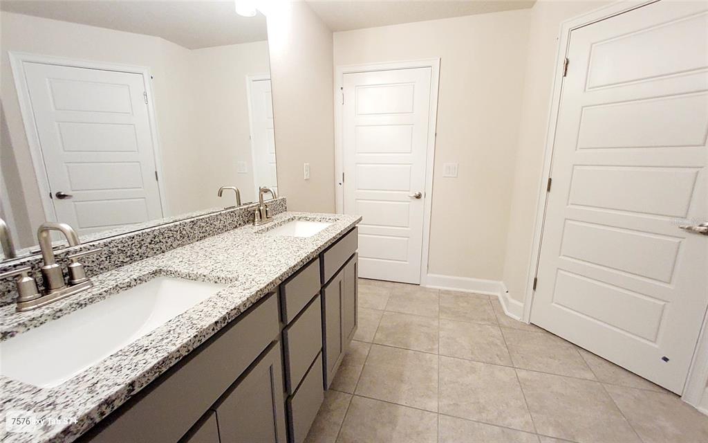 7560 Bent Tree Loop St. Cloud, FL 34773 - Photo 13 of 25 a bathroom with a granite countertop sink and a mirror