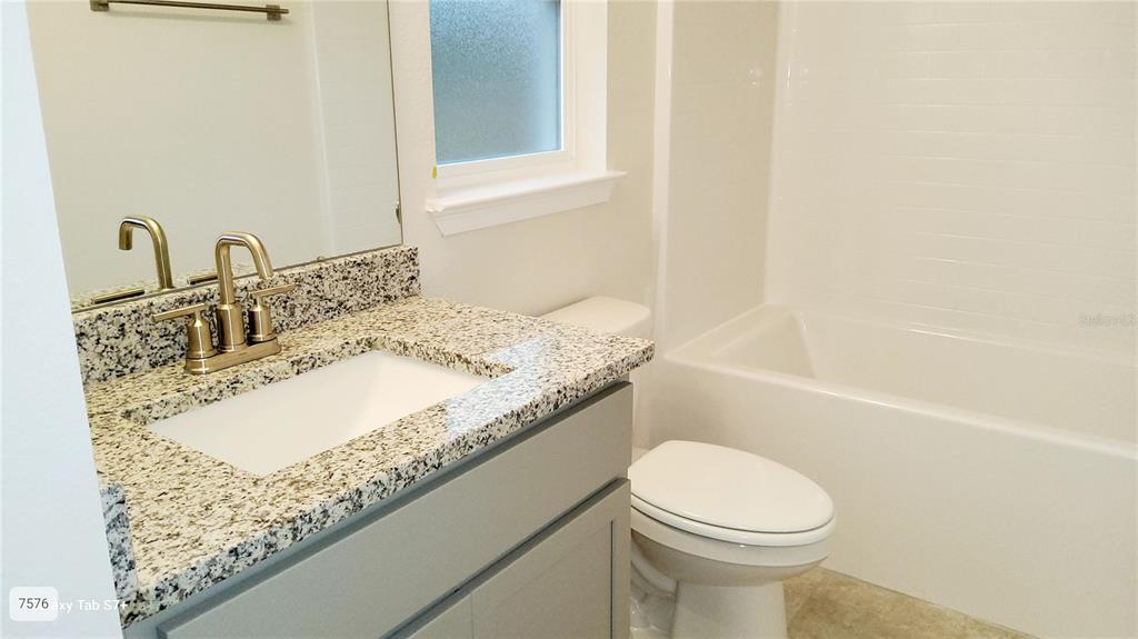 7560 Bent Tree Loop St. Cloud, FL 34773 - Photo 17 of 25 a bathroom with a granite countertop sink toilet and shower