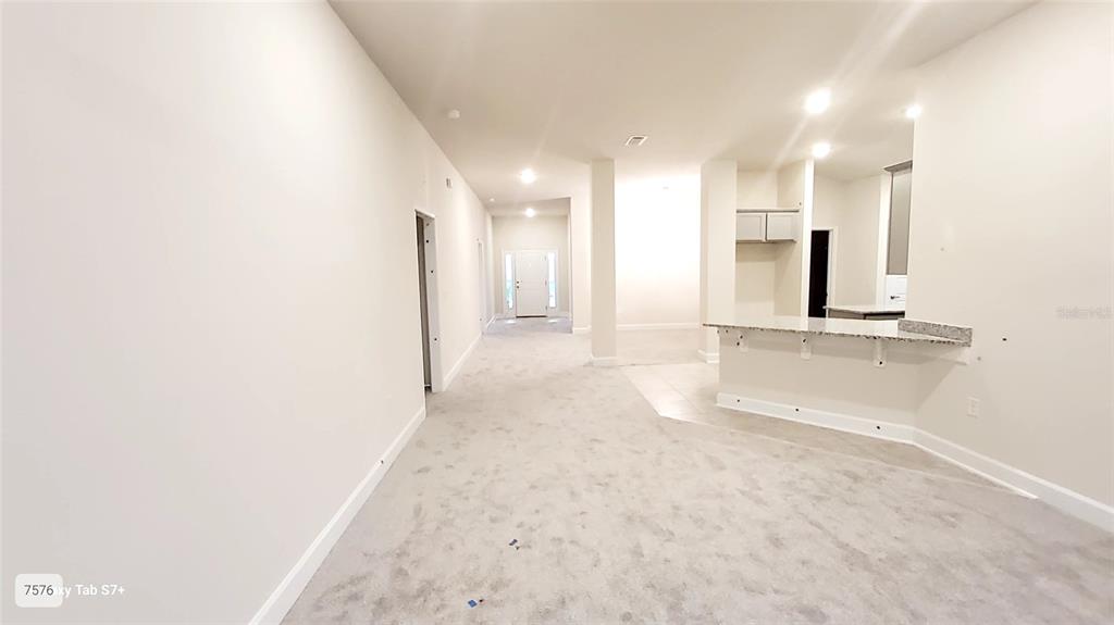 7560 Bent Tree Loop St. Cloud, FL 34773 - Photo 19 of 25 a view of a hallway with a kitchen