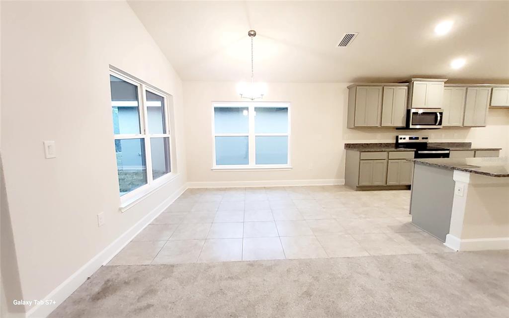 7560 Bent Tree Loop St. Cloud, FL 34773 - Photo 21 of 25 a kitchen with stainless steel appliances granite countertop a stove a sink and a refrigerator