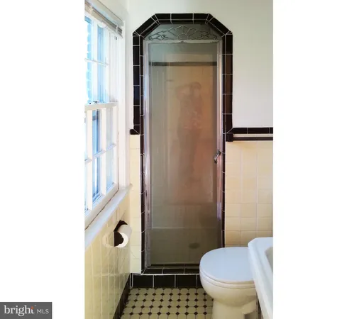 a bathroom with a toilet and a shower