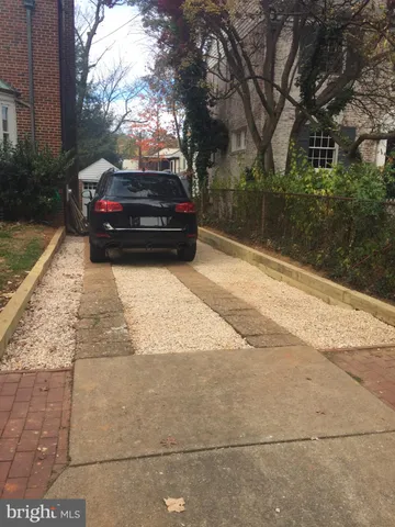 a view of a yard with cars parked on the road
