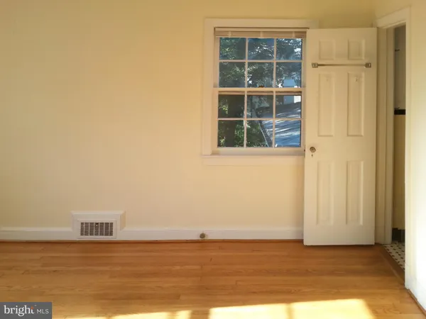 a view of a room with wooden floor and windows