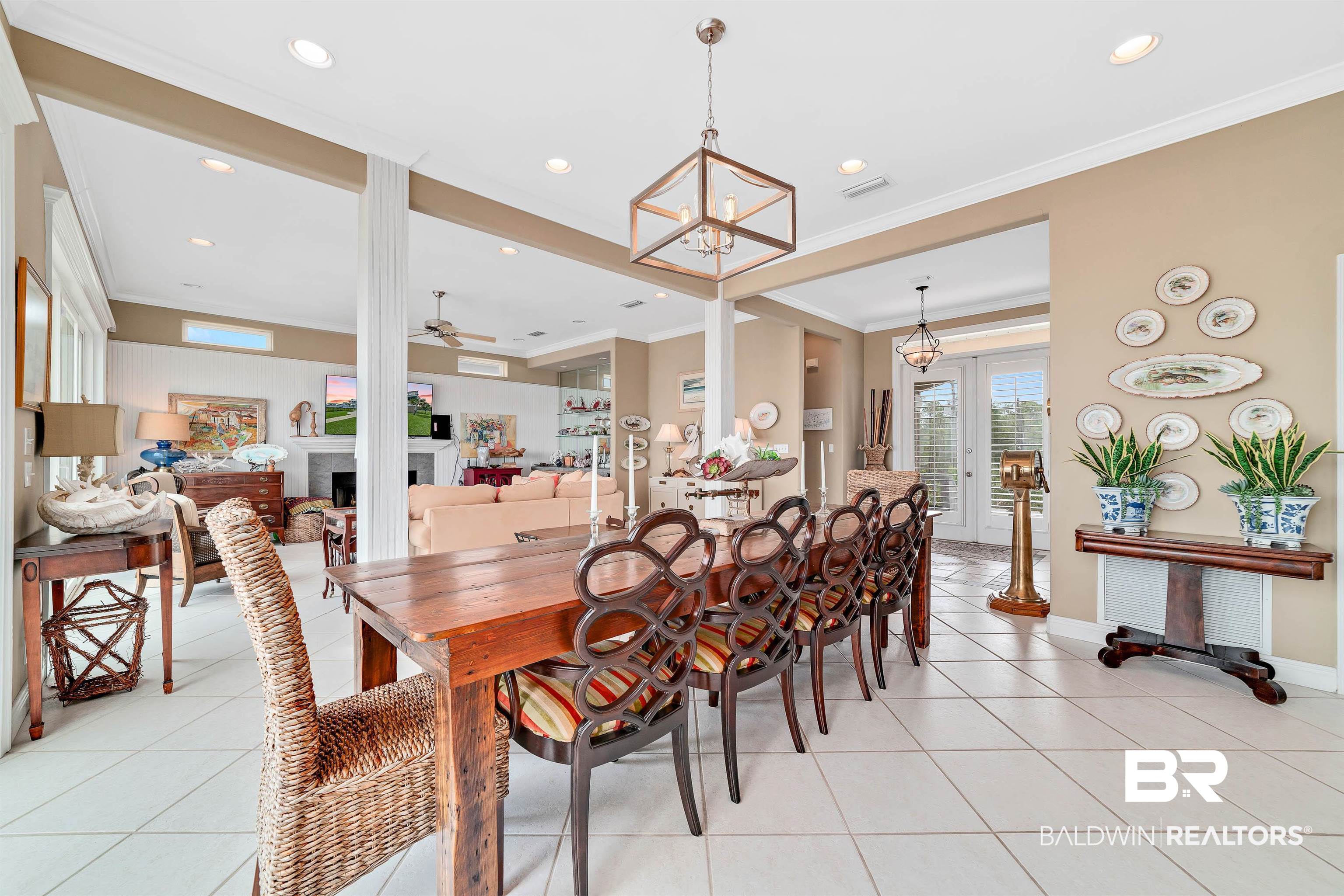 24513 Gulf Bay Road Orange Beach, AL 36561 - Photo 11 of 52 Tiled dining room featuring crown molding, french doors, and ceiling fan with notable chandelier