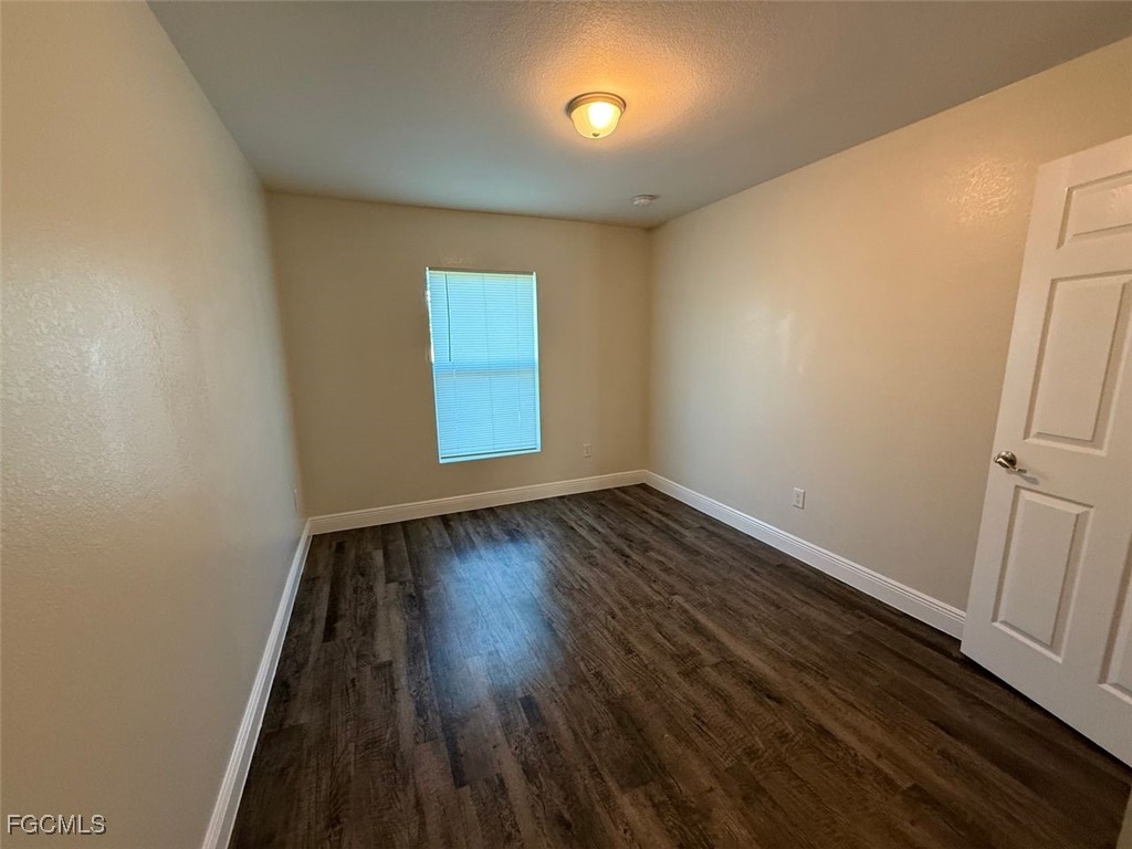 3003 Harvard Circle LaBelle, FL 33935 - Photo 4 of 11 an empty room with wooden floor and windows