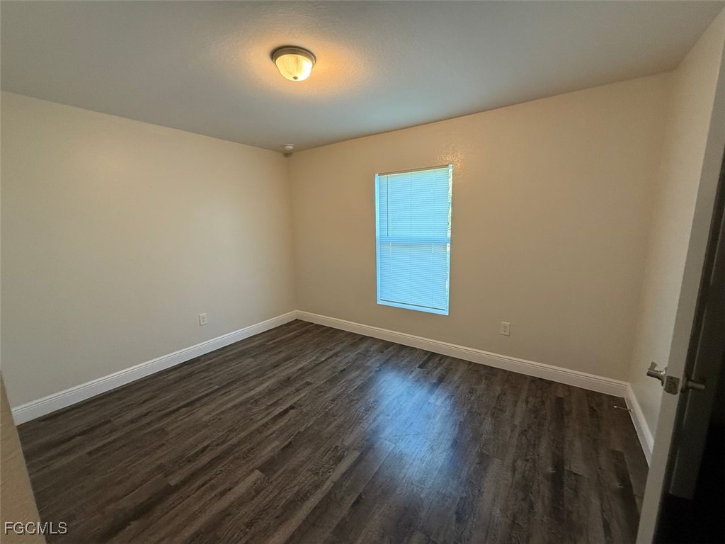 3003 Harvard Circle LaBelle, FL 33935 - Photo 6 of 11 an empty room with wooden floor and windows