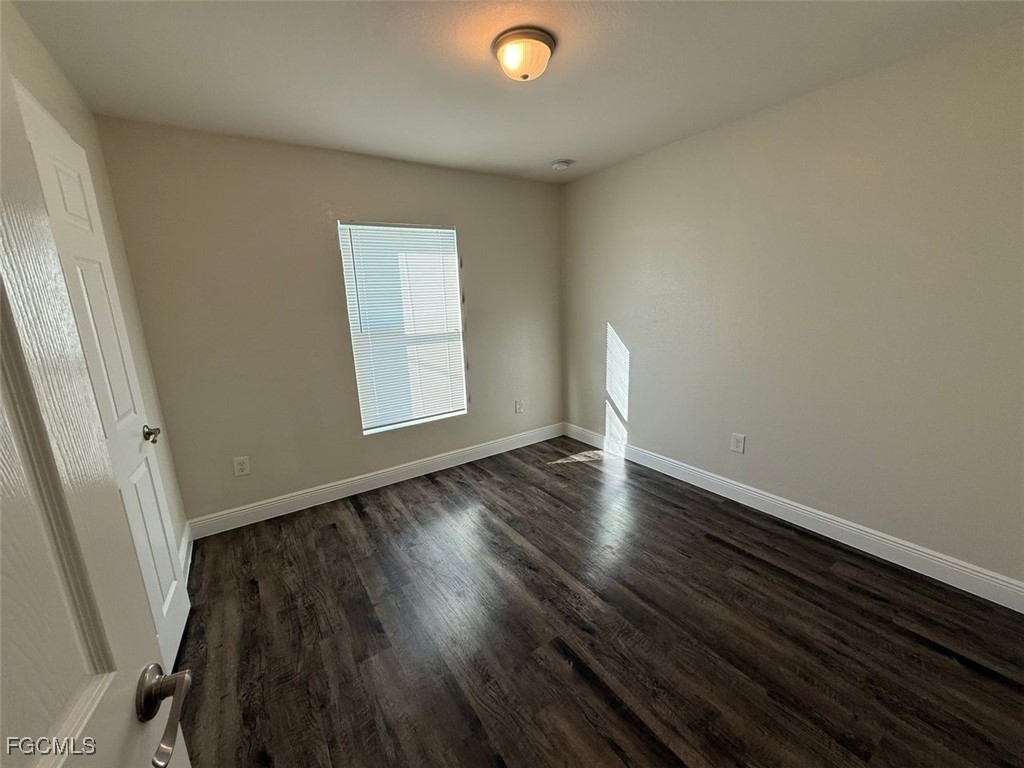 3003 Harvard Circle LaBelle, FL 33935 - Photo 8 of 11 an empty room with wooden floor and windows