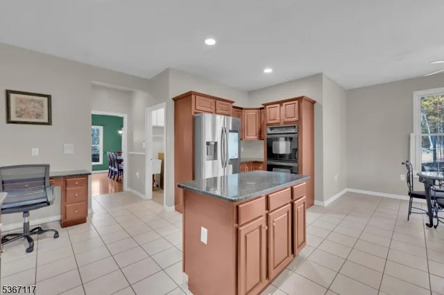 a kitchen with stainless steel appliances granite countertop a refrigerator and a stove