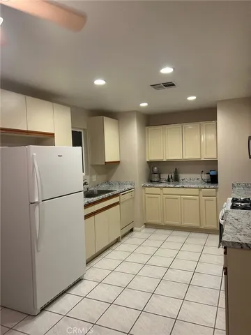 a kitchen with granite countertop cabinets and white appliances
