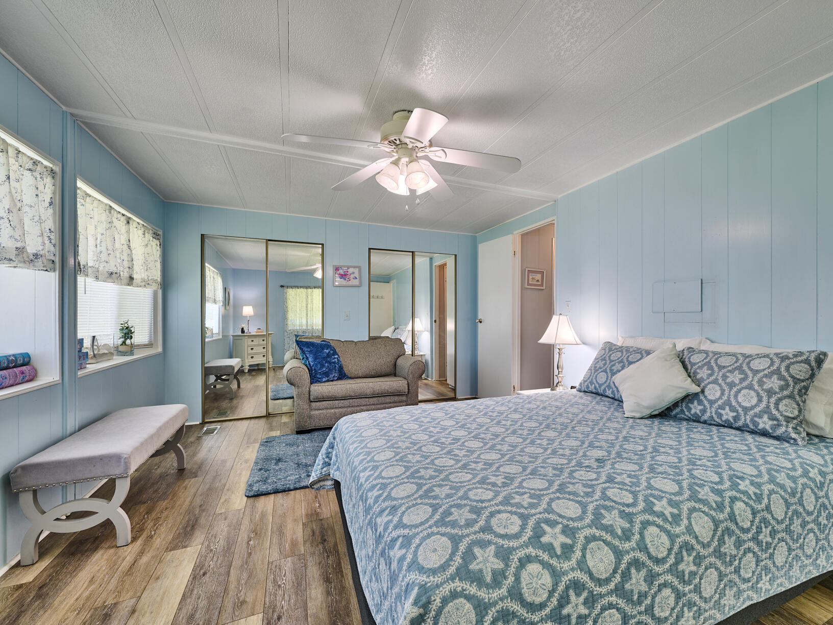 6977 Southeast Delegate Street Hobe Sound, FL 33455 - Photo 29 of 60 a bedroom with a large bed and a chandelier