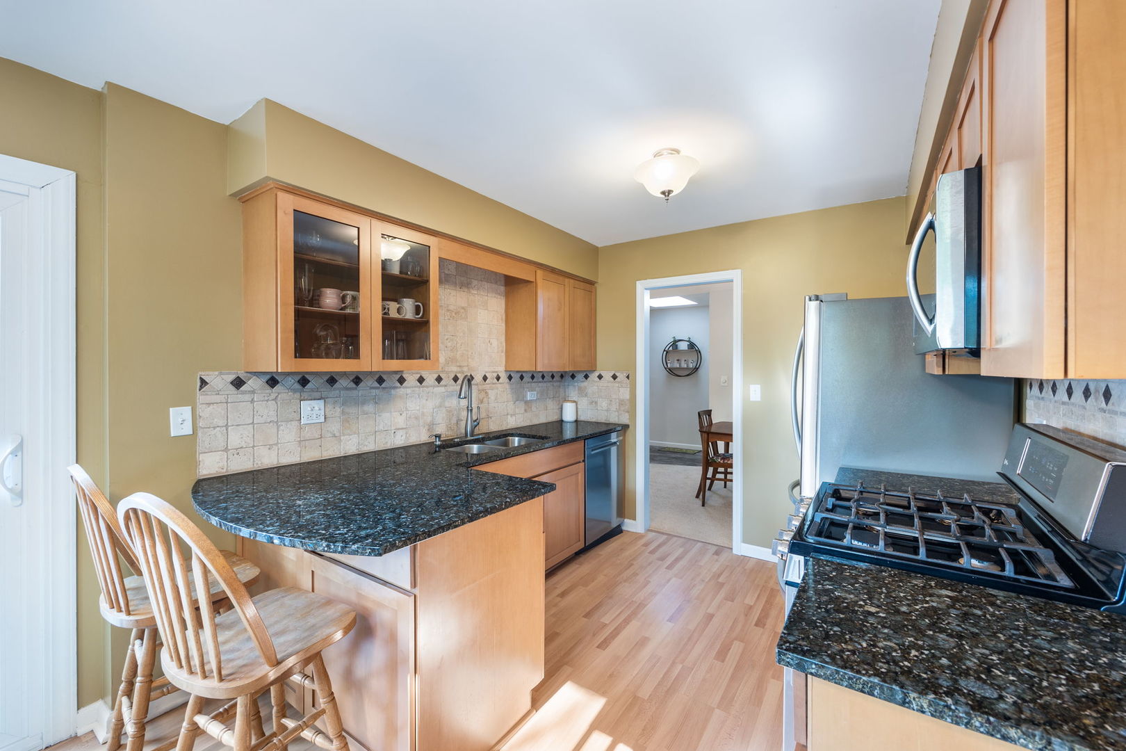 1932 Gresham Circle, Unit C Wheaton, IL 60189 - Photo 11 of 27 a kitchen with granite countertop a sink stove and refrigerator