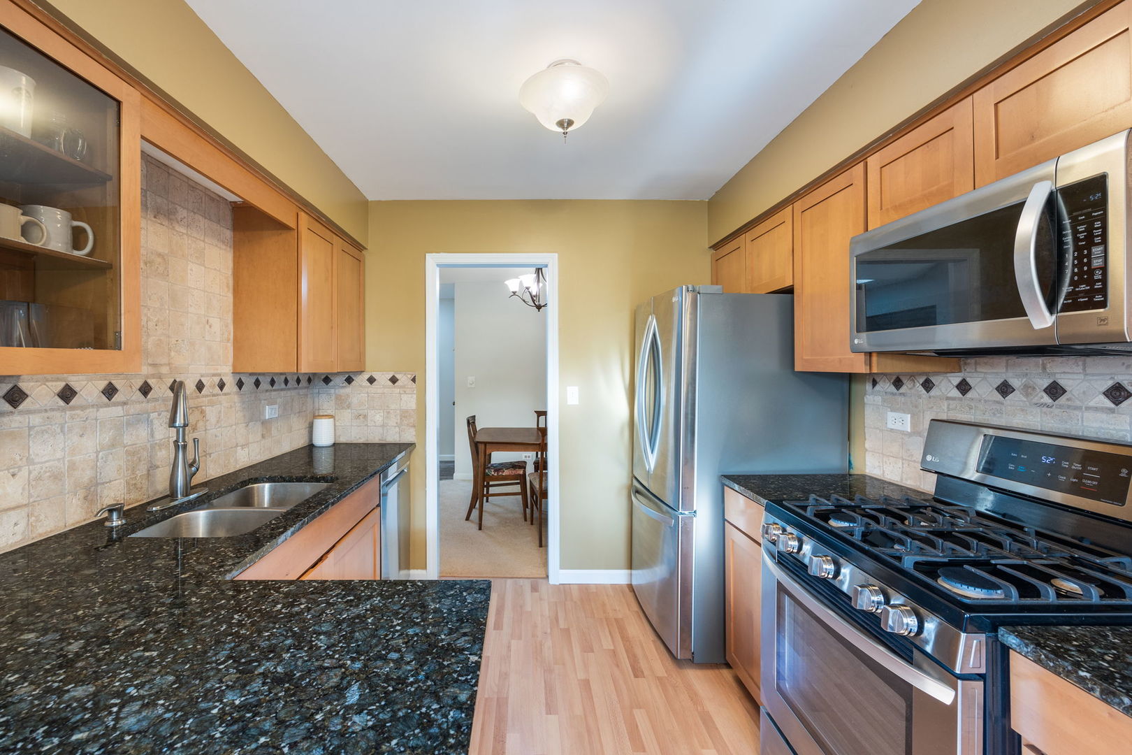 1932 Gresham Circle, Unit C Wheaton, IL 60189 - Photo 12 of 27 a kitchen with stainless steel appliances granite countertop a stove a refrigerator and a microwave