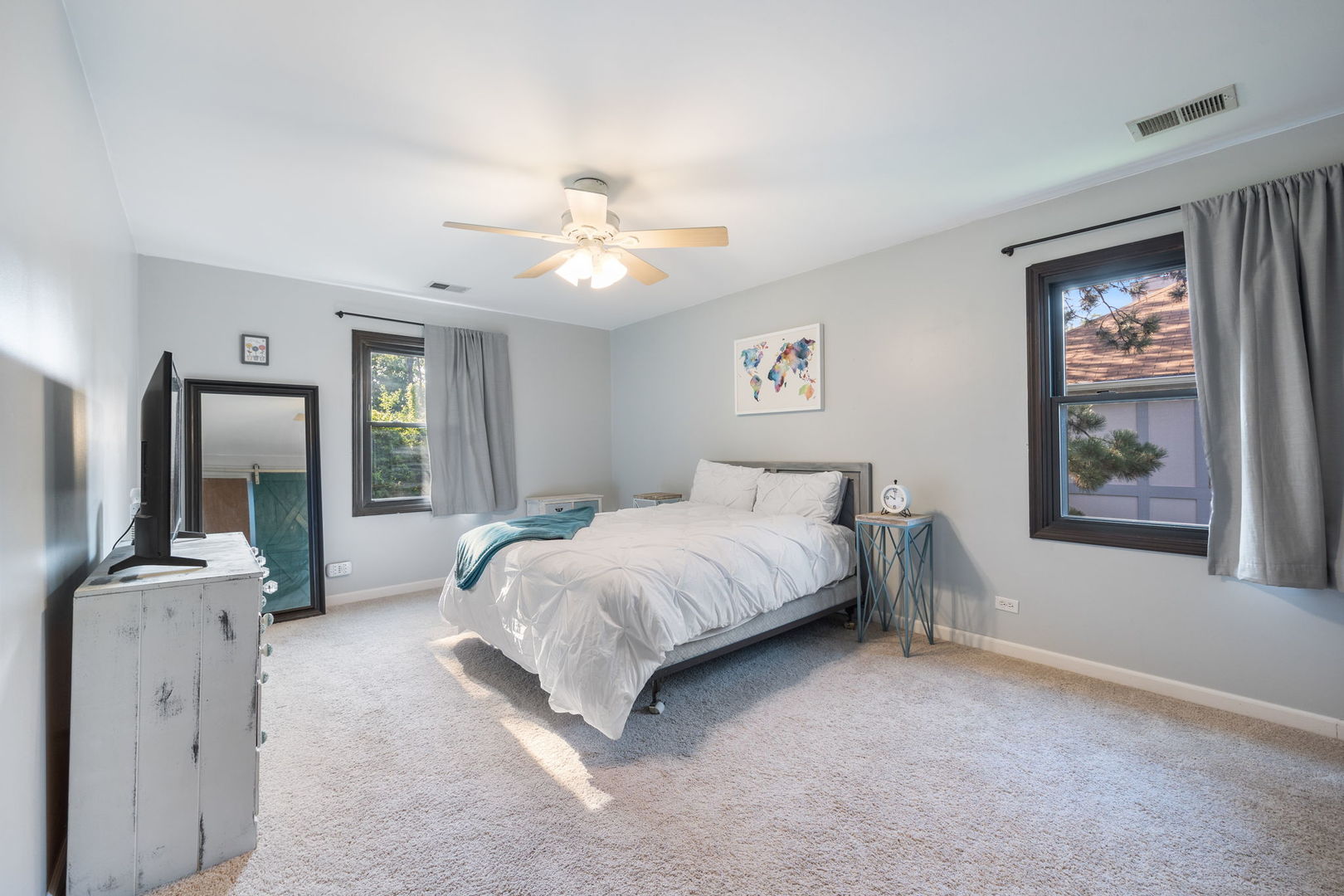 1932 Gresham Circle, Unit C Wheaton, IL 60189 - Photo 15 of 27 a spacious bedroom with a bed a dresser and potted plant on the dresser
