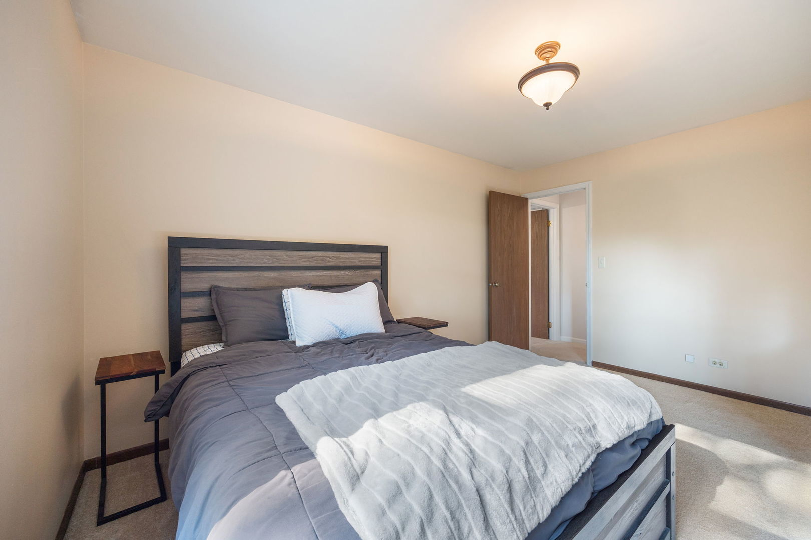 1932 Gresham Circle, Unit C Wheaton, IL 60189 - Photo 20 of 27 a bedroom with a large bed and a chandelier