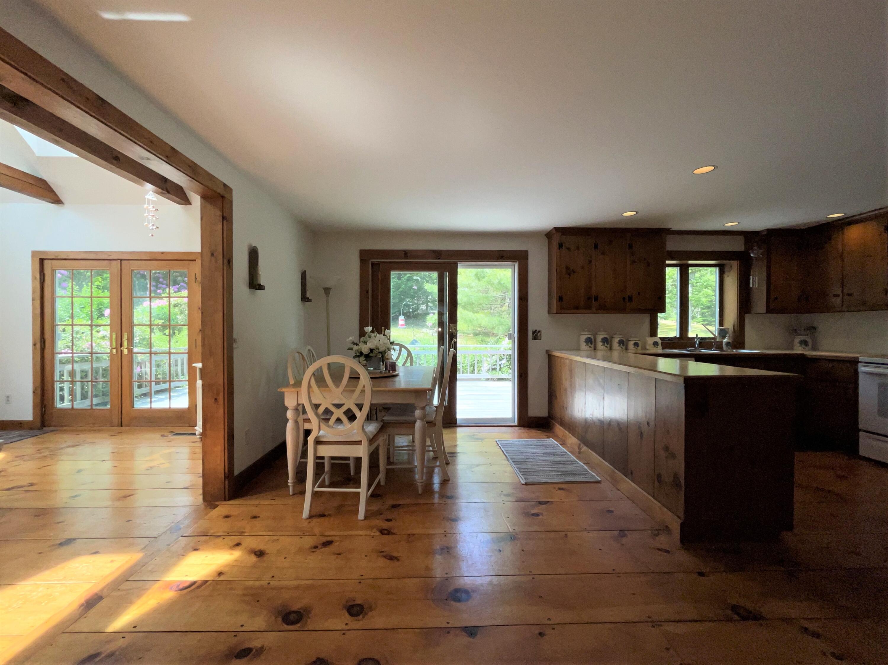 144 Long Road Harwich, MA 02645 - Photo 23 of 49 a kitchen with stainless steel appliances granite countertop a stove top oven a sink dishwasher a dining table and chairs with wooden floor