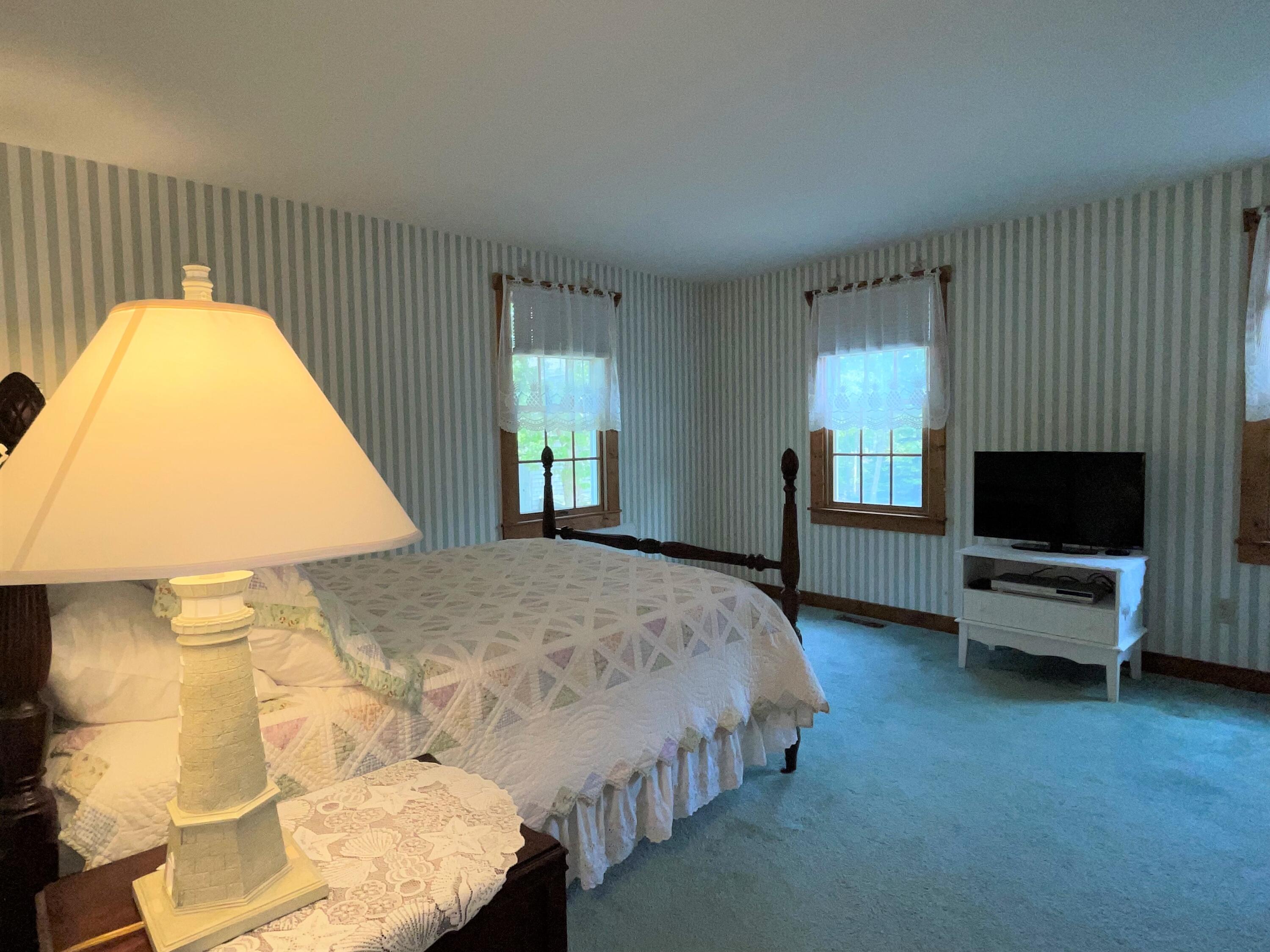 144 Long Road Harwich, MA 02645 - Photo 34 of 49 a spacious bedroom with a bed and a flat screen tv