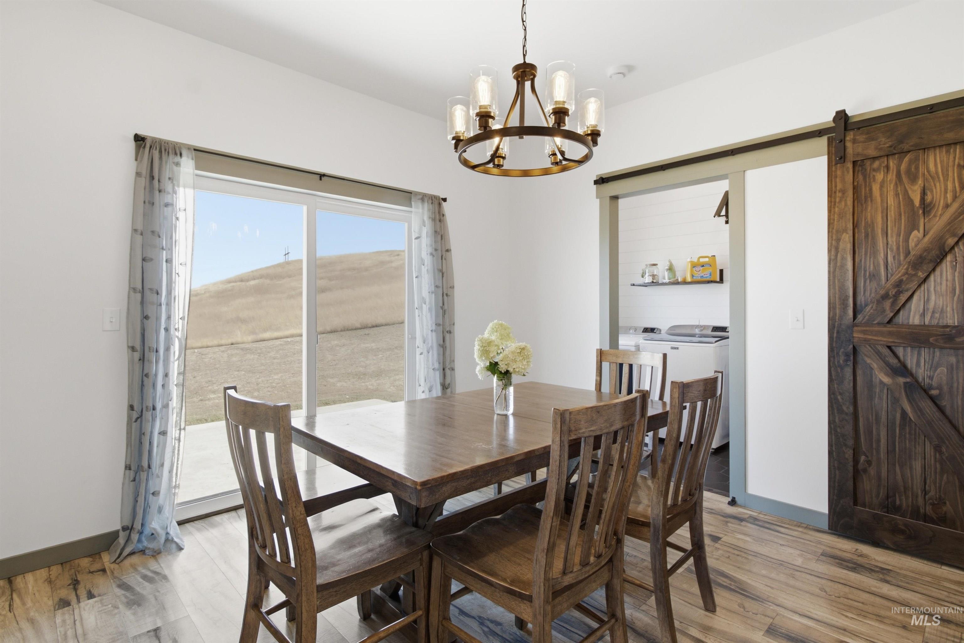 1032 Duffield Flat Road Potlatch, ID 83855 - Photo 14 of 50 Wood-finish flooring, sliding glass door, modern chandelier, and a dark wood barn door