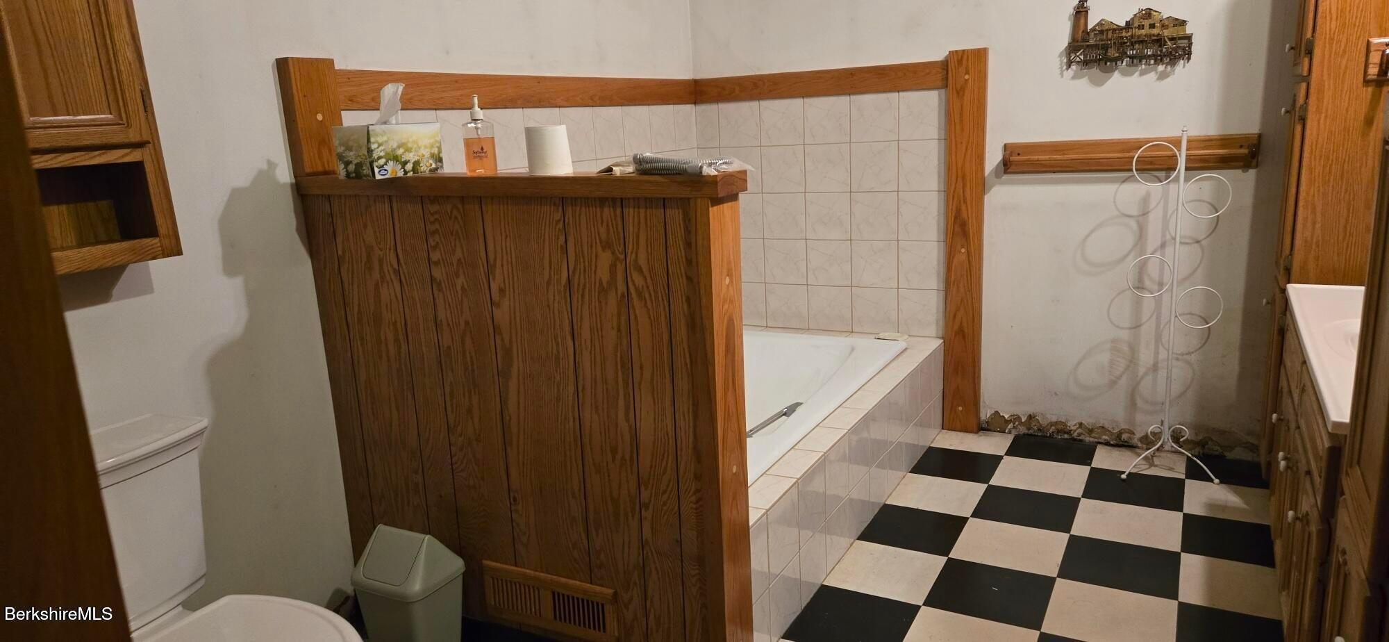 364 Otis Road Becket, MA 01223 - Photo 5 of 8 a bathroom with a black white checkered floor and a sink