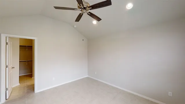 an empty room with a ceiling fan and a window