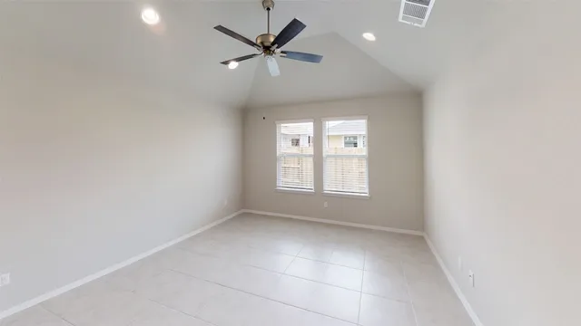 an empty room with windows and fan