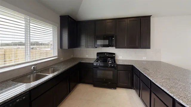 a kitchen with a sink stove and microwave