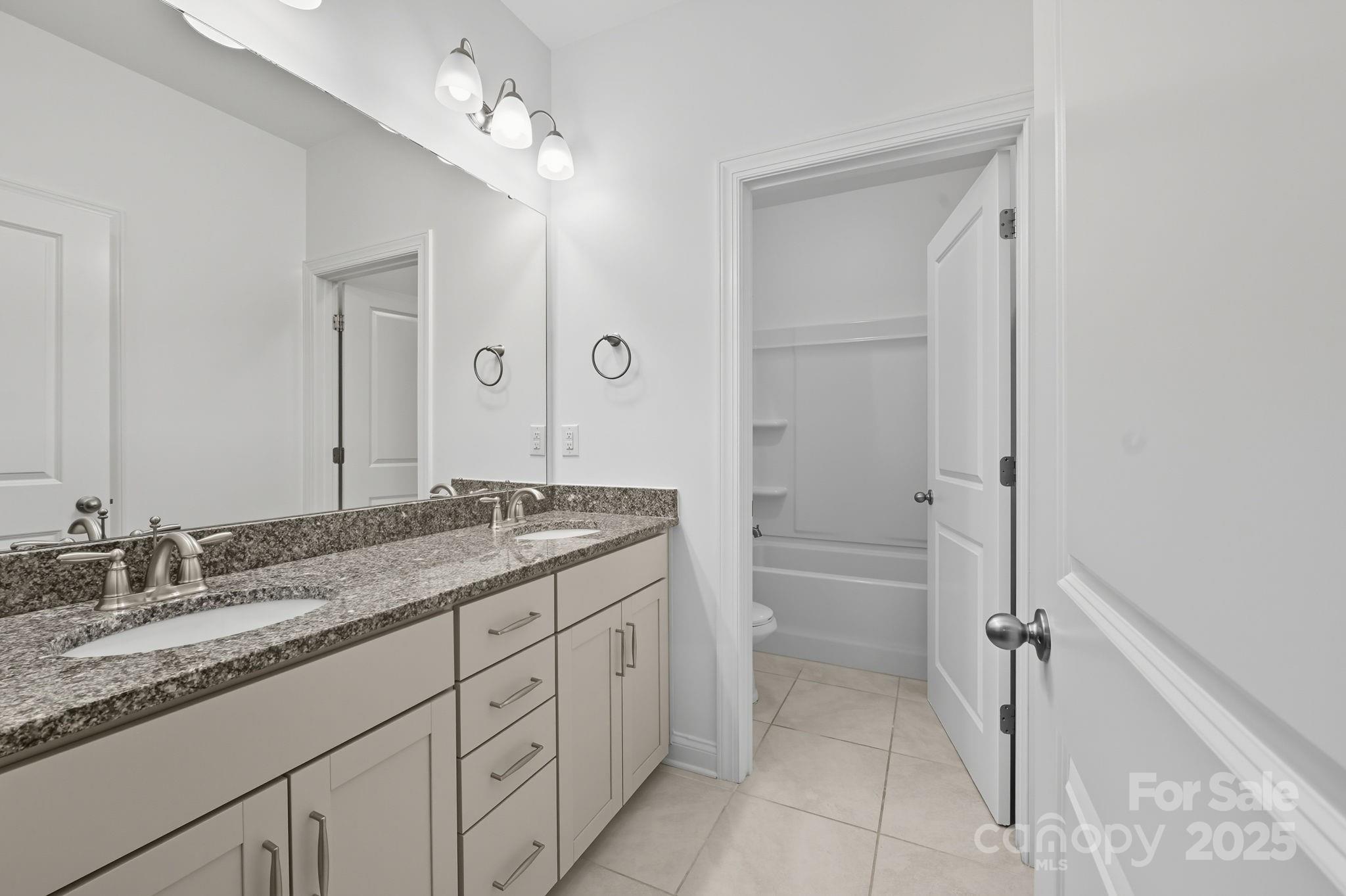425 Cassia Court Tega Cay, SC 29708 - Photo 33 of 39 a bathroom with a granite countertop sink a mirror and a